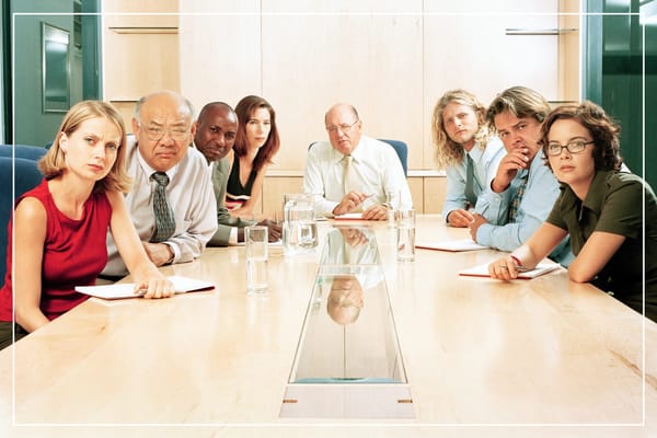 Office employees sitting around a boardroom table
